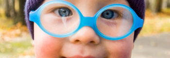 close up of a baby's face with glasses on