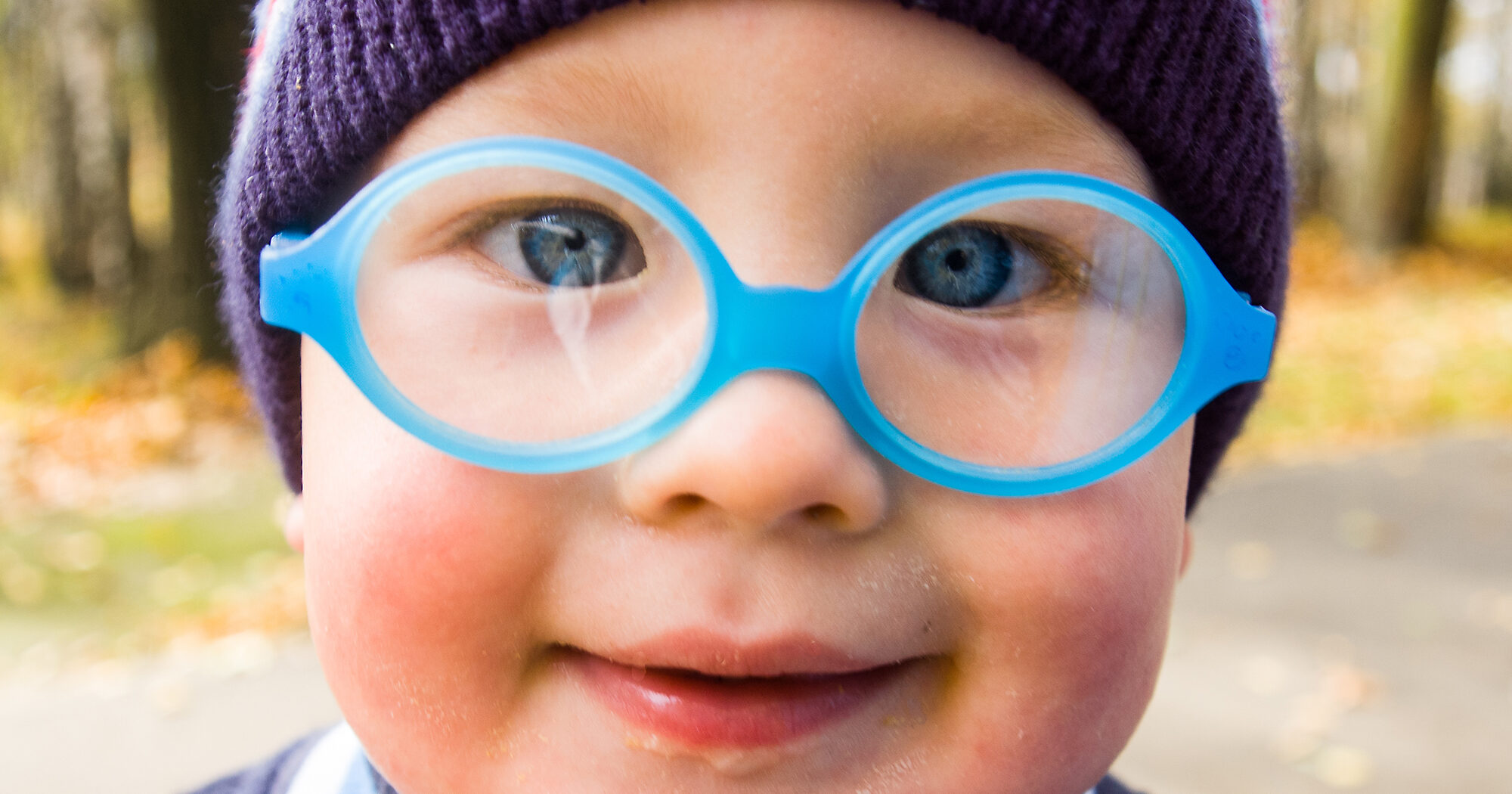 close up of a baby's face with glasses on